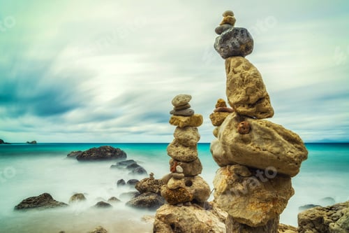 Preview: A balanced pile of stones in front of the waves