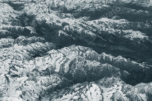 Preview: Aerial view of high rocky mountains covered with snow. Alpine landscape. Inaccessible mountain peaks