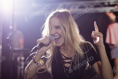 Preview: Happy young female singer performing at nightclub