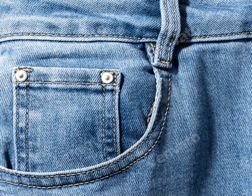 Preview: Front pocket and small pocket of blue jeans pants. Macro close up.