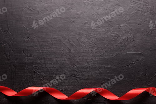 Preview: Happy Valentines Day. Red Ribbon on black stone background. Valentines Day concept