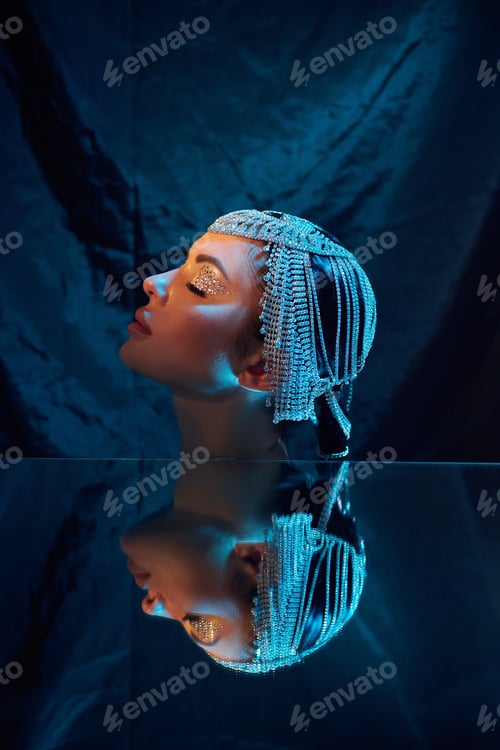 Vista previa: Model poses with unique headpiece in a studio setting at night
