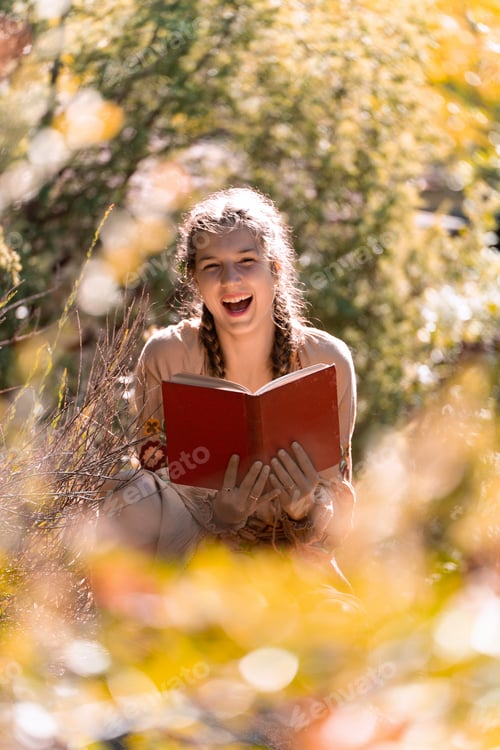 Preview: Happy woman reading a book in the nature.