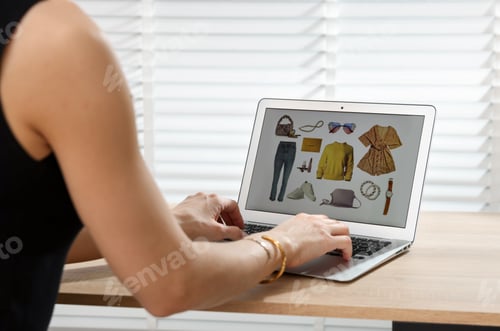 Preview: Professional stylist making collage with outfit on laptop at desk indoors, closeup