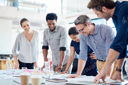 Preview: Group of diverse professionals gathered at a table to look at a strategic plan