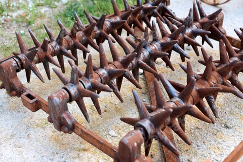 Preview: Rusty harrow spiked farm equipment on concrete