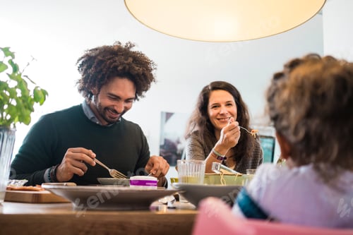 Preview: Happy family eating together pizza and pasta