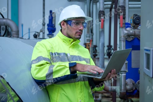 Preview: Engineer specialist using laptop checking and maintaining machine in factory