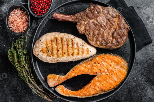 Preview: Grilled meat steaks - fish salmon, beef veal and turkey fillet. Black background. Top view