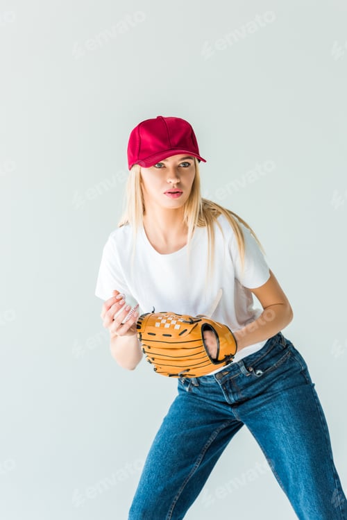Preview: attractive baseball player in red cap holding baseball ball and glove isolated on white