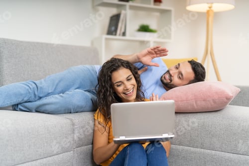 Preview: Young Couple Video Chatting on Laptop at Home