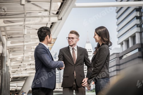 Preview: Business partner shaking and smiling while meeting in front of office. Business success concept.