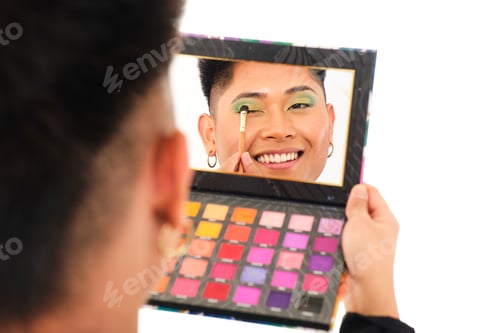Preview: non binary asian person putting on makeup with a makeup case with mirror on white background