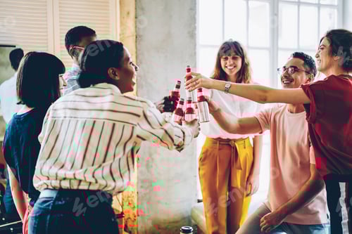 Preview: Young people clinking bottles in loft