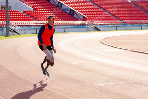 Preview: Asian para-athletes with prosthetic blades sprint on a running track at stadium.