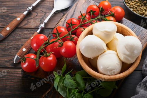 Preview: Caprese salad, ingredients for cooking. Cutting wooden board with traditional caprese preparation in