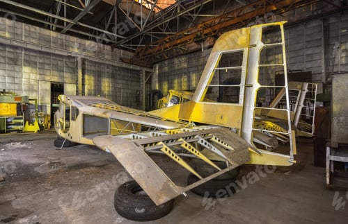 Preview: The partially-built airplane in a dark industrial building at night