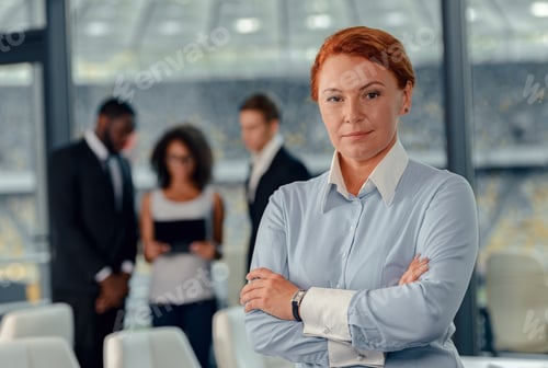 Preview: Portrait of businesswoman with crossed hands standing in office