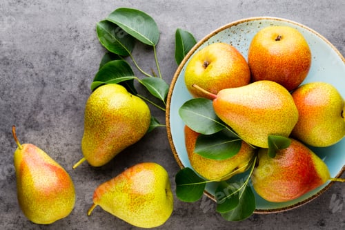 Preview: Fresh bio pear with leaves on the plate. Gray stone table.