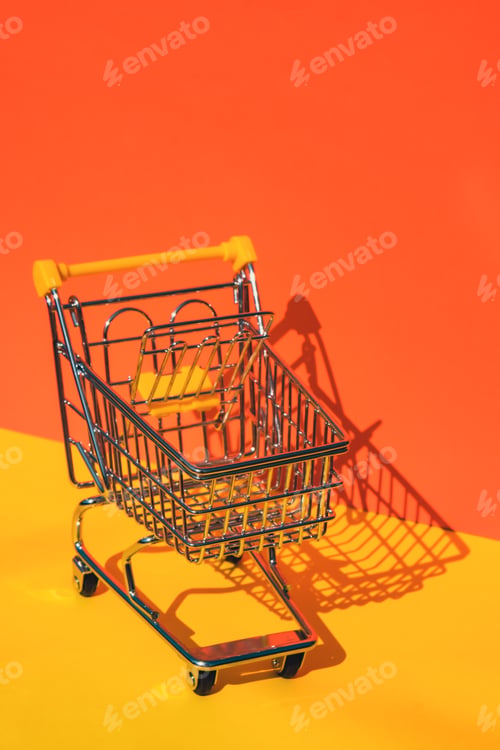 Preview: Empty shopping trolley cart on colorful orange yellow background. Copy space for your text. Online