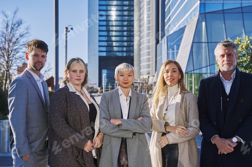 Preview: young asian woman with white hair and suit leading a group of company owners looking at the camera