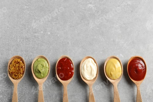 Preview: Wooden spoons with different sauces and space for text on gray background, flat lay