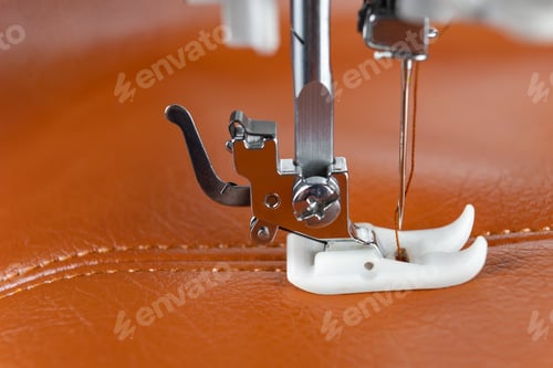Preview: Modern sewing machine presser foot with a needle sews brown leather