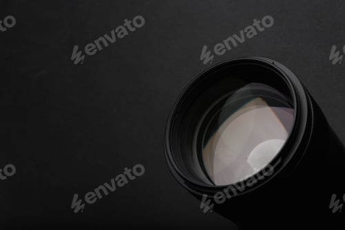 Preview: Modern camera lens on black background, closeup. Space for text