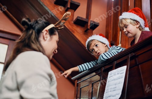 Preview: Shot of a young woman playing the piano for her sons at Christmas