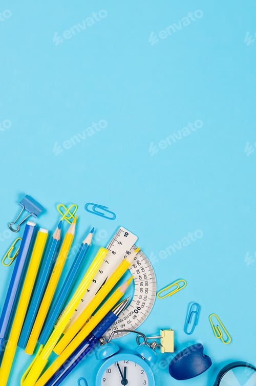 Preview: Blue and yellow school stationery on blue background.
