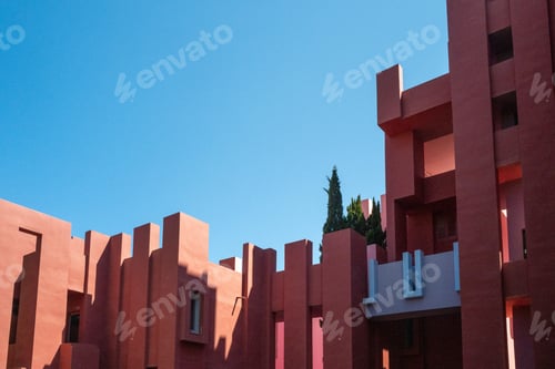 Preview: Modern red building against a vibrant clear blue sky.