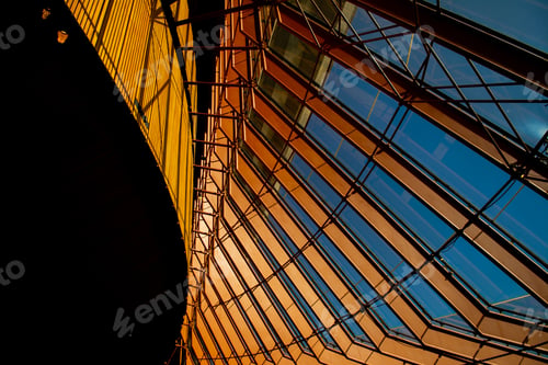 Preview: Modern abstract building with colorful metallic columns under a blue sky