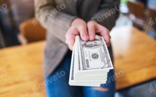 Preview: a woman holding and showing American dollar banknotes for money and financial concept
