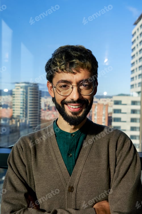 Preview: Headshot of a man looking at camera smiling at work office.