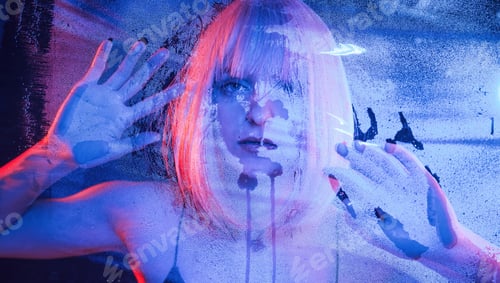 Preview: Cold blue color. With hands on the wet transparent plastic sheet. Stylish woman with white hair