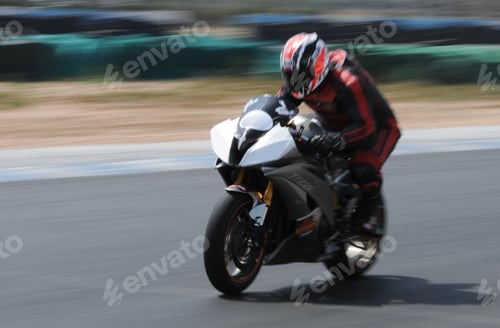 Preview: Motorcycle rider leaning into a fast turn. Endurance racing