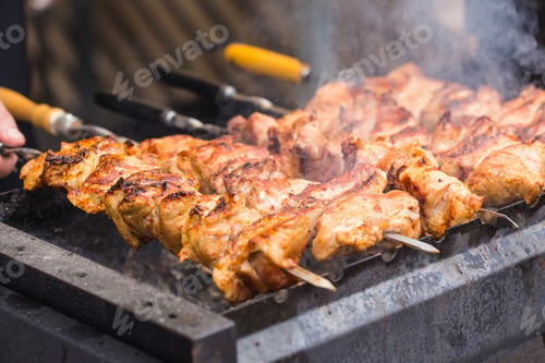 Preview: Delicious bbq kebab grilling on open grill, outdoor kitchen. Food festival in city. Tasty food