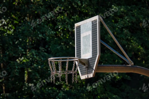 Preview: a basketball hoop near a forest with green trees in the background