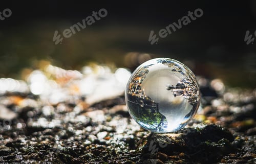 Preview: clear glass globe is sitting on rocky surface