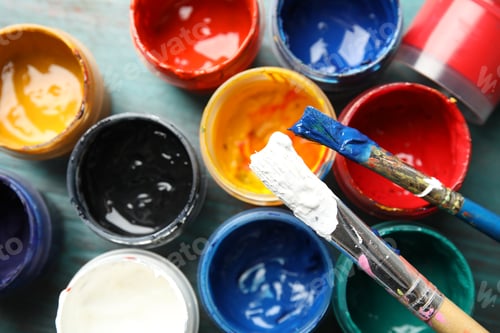 Preview: Jars with color paints and brushes on table, top view