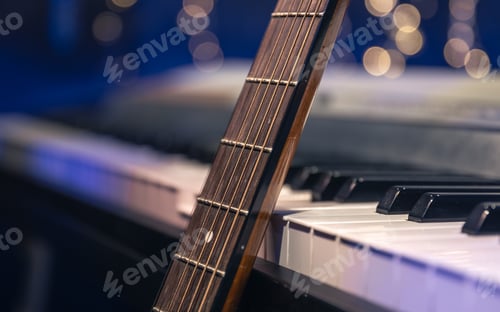 Preview: Guitar and piano keys close-up on a blurred background with bokeh.