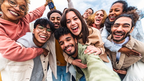Preview: Multicultural young people smiling together at camera outside