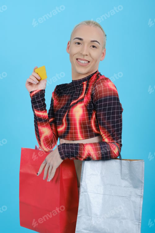 Preview: Non-binary person holding a credit card and shopping bags while standing over an isolated background
