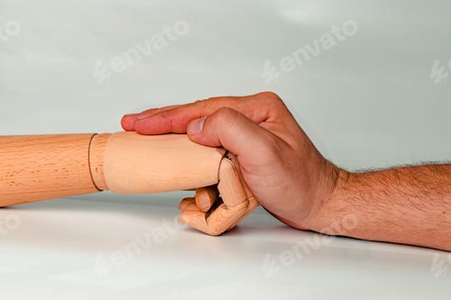 Preview: Wooden hand hitting a hand of a person.