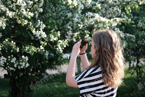 Preview: Teen Taking Pictures of Flowering Tree with Phone