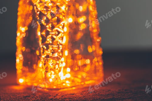 Preview: Christmas lights garland put in bottle in the dark close up