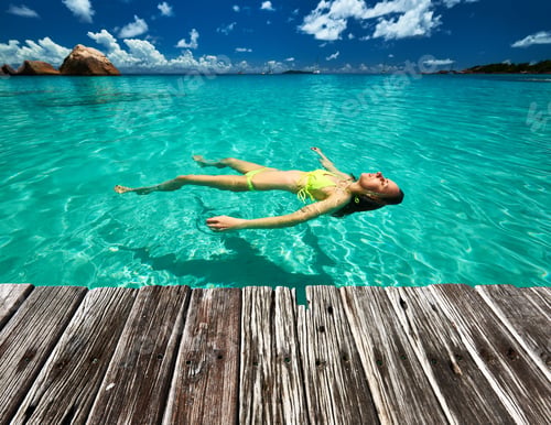 Preview: Woman In Bikini Lying On Water At Tropical Beach