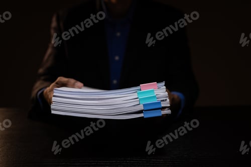 Preview: a businessman works overtime is his accounting firm's office until late at night