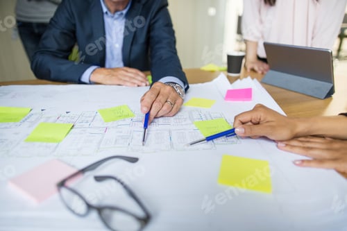 Preview: Architects discussing blueprint in office