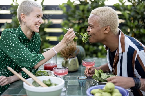 Preview: Woman feeding salad to boyfriend during dinner